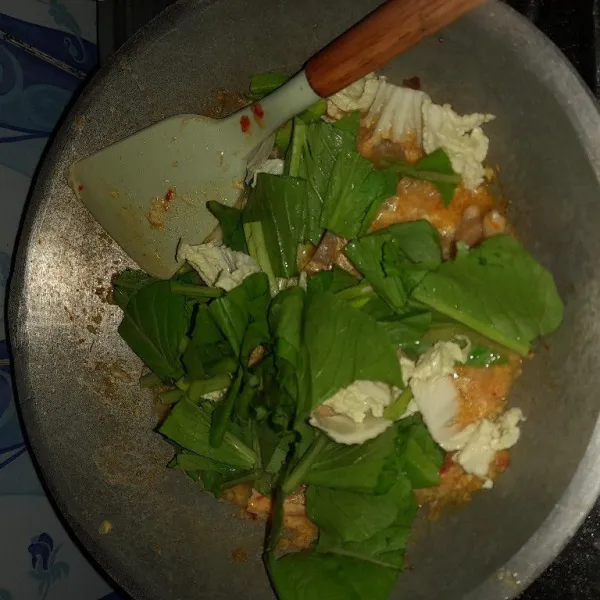Masukkan telur yang telah dikocok, aduk rata. Masukkan sawi hijau dan sawi putih, masak hingga matang. Sajikan dengan taburan daun bawang.