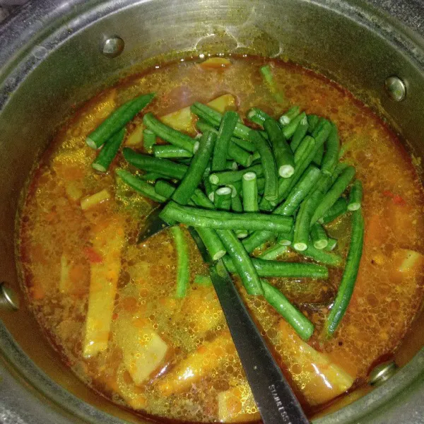 Masukkan nangka muda dan kacang panjang, masak sampai bumbu matang.