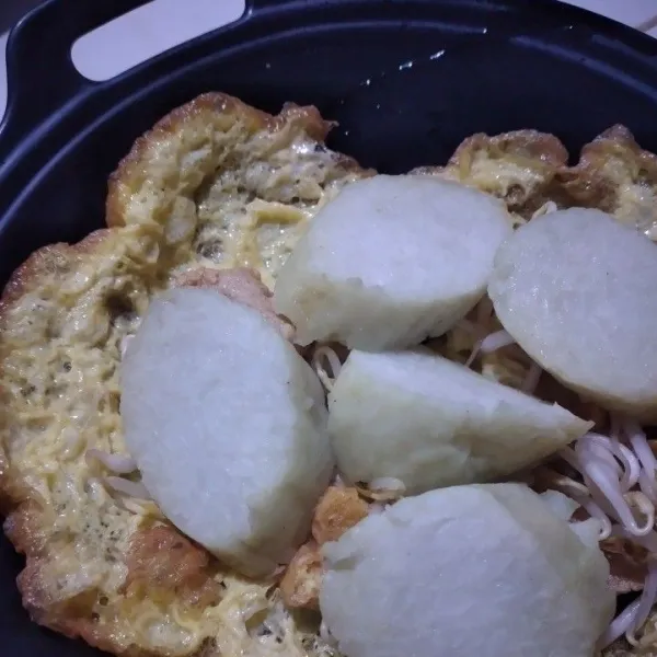 Tata tahu telur goreng, tambahkan irisan lontong.
