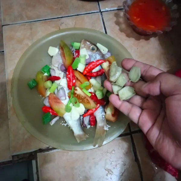 Lalu tambahkan irisan daun bawang dan jahe di atasnya.