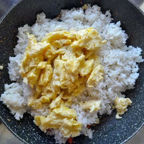 Masukkan nasi dan telur orak-arik. Aduk hingga tercampur rata.