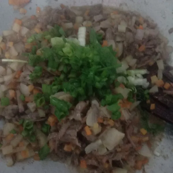 Masukkan kentang dan wortel, tumis hingga layu/empuk lalu tambahkan garam, gula, merica bubuk, dan kaldu sapi bubuk serta tambahkan juga irisan daun bawang, koreksi rasa. Tumis hingga harum.