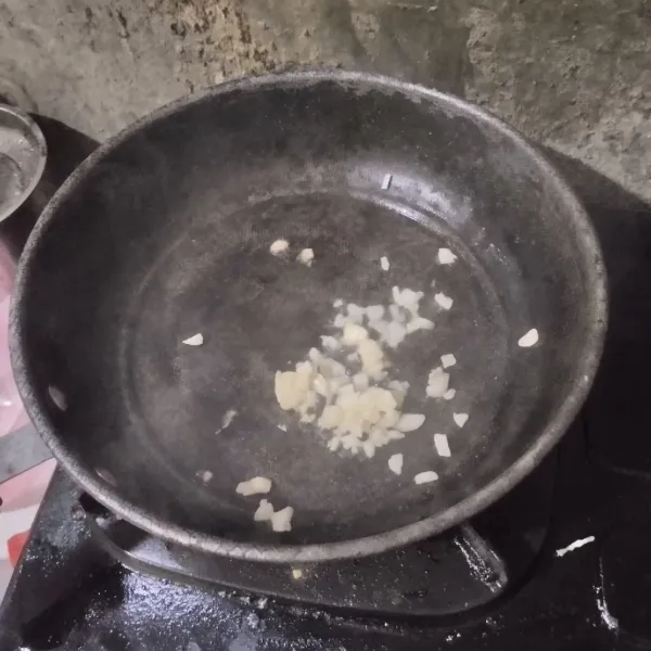 Tumis bawang putih hingga harum.