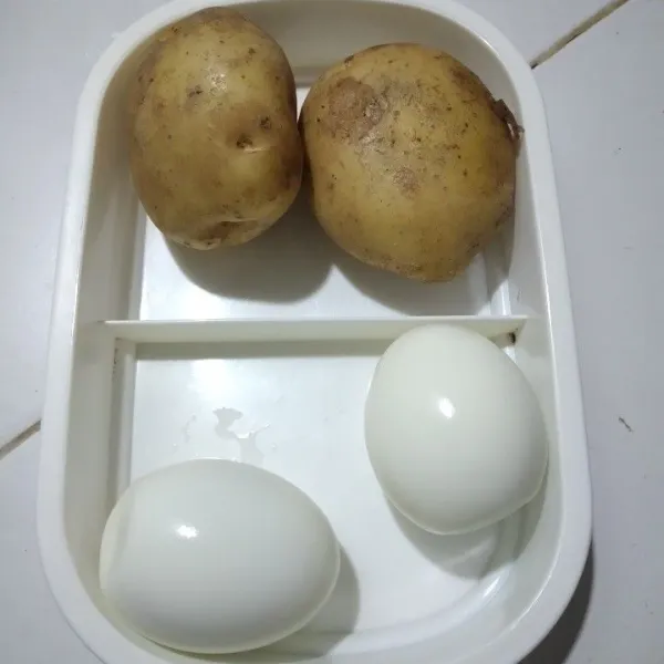 Kupas telur rebus, kukus atau rebus 1 buah kentang.