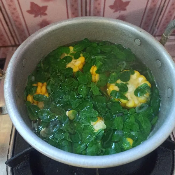 Setelah rasanya sesuai, masukkan daun kelor dan daun kemangi, masak kurang lebih selama 1 menit saja supaya tidak langu, aduk rata, kemudian matikan api.