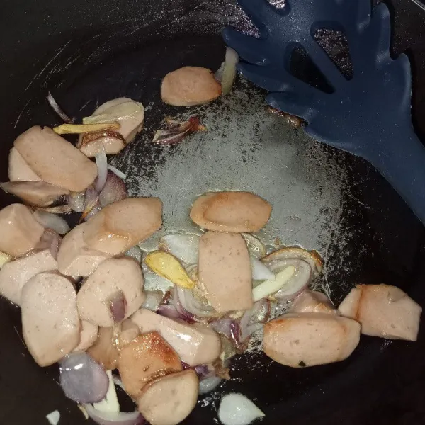 Tumis bawang merah, bawang putih hingga harum dengan minyak secukupnya kemudian masukkan sosis, aduk rata.
