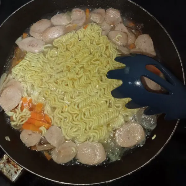 Setelah wortel mulai matang, masukkan mie. Rebus mie hingga matang.