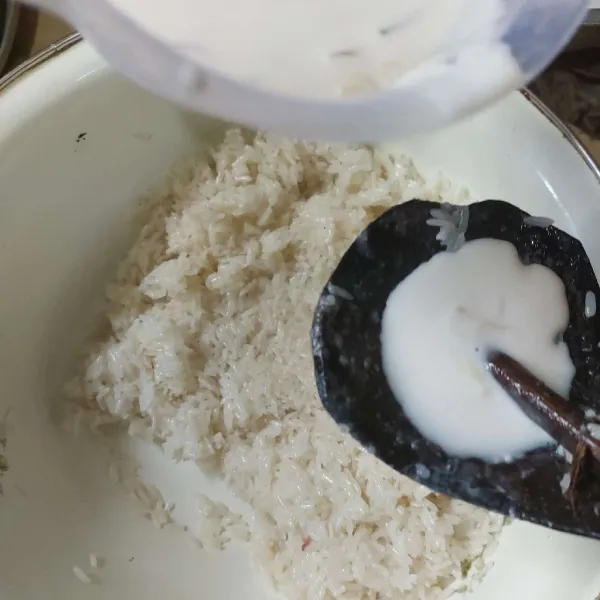 Tuang sedikit santan ke ketan yang masih panas.