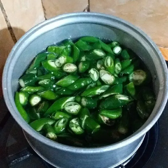 Potong serong cabe hijau kemudian cuci bersih lalu rebus sebentar agar tidak langu.