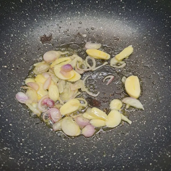 Tumis bawang merah dan bawang putih sampai layu dan harum.
