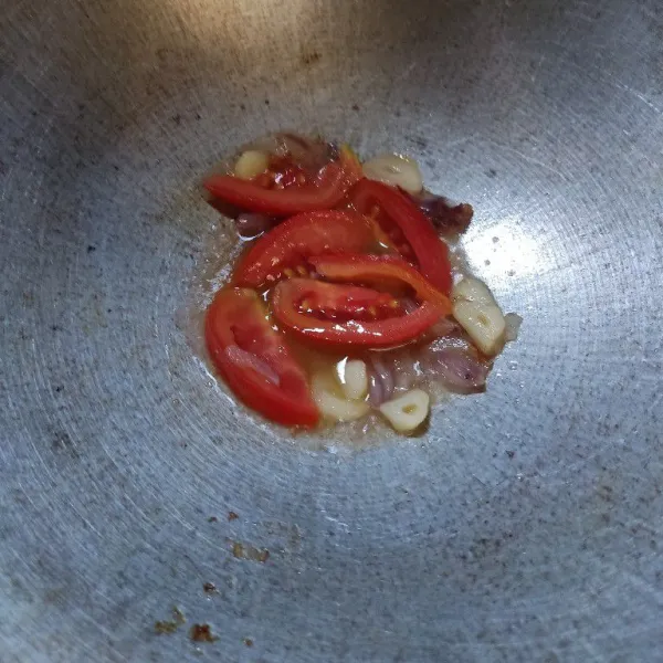 Sisihkan secukupnya minyak sisa menggoreng telur, tumis duo bawang, dan tomat hingga layu.