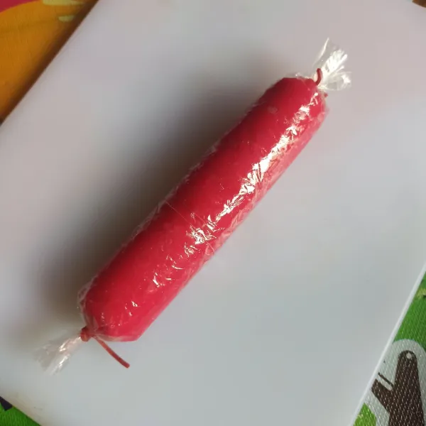 Keluarkan loyang dari kukusan, biarkan uap panasnya hilang. Setelah itu, keluarkan kue pepe dari loyang. Taruh di atas plastik , lapisan yang warna merah di bawah ya. Lalu gulung menggunakan plastik. Sambil ditekan-tekan atau diikat juga bisa ya. Diamkan sampai suhu ruang atau bisa simpan di kulkas sampai set.