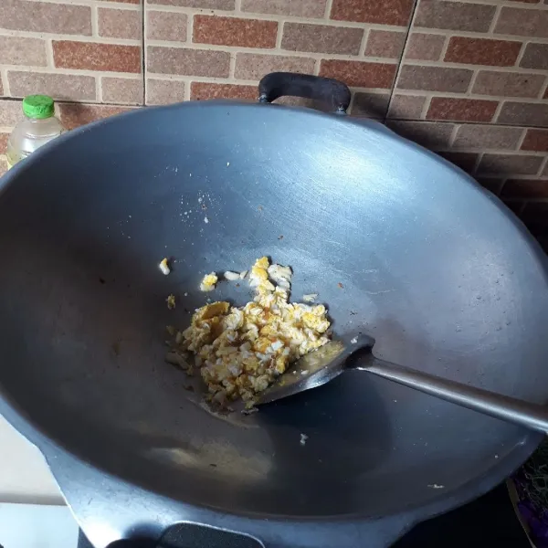 Goreng 1 butir telur dan orak-arik, masukkan bawang putih, masak hingga harum.