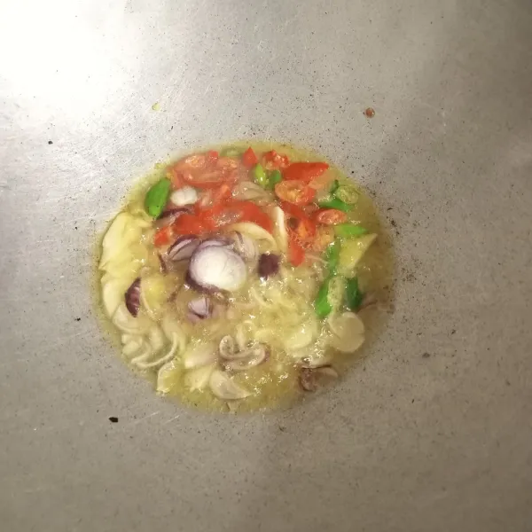 Panaskan minyak kemudian masukkan bawang merah, bawang putih, cabai rawit merah, dan cabai rawit hijau yang sudah diiris.