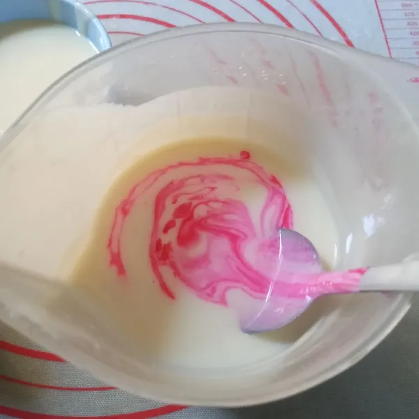 Saring cream kemudian ambil 150 ml, sisihkan. Sisanya beri pewarna pink, aduk rata.
