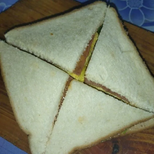 Potong roti menjadi 4 bagian berbentuk segitiga, sajikan.