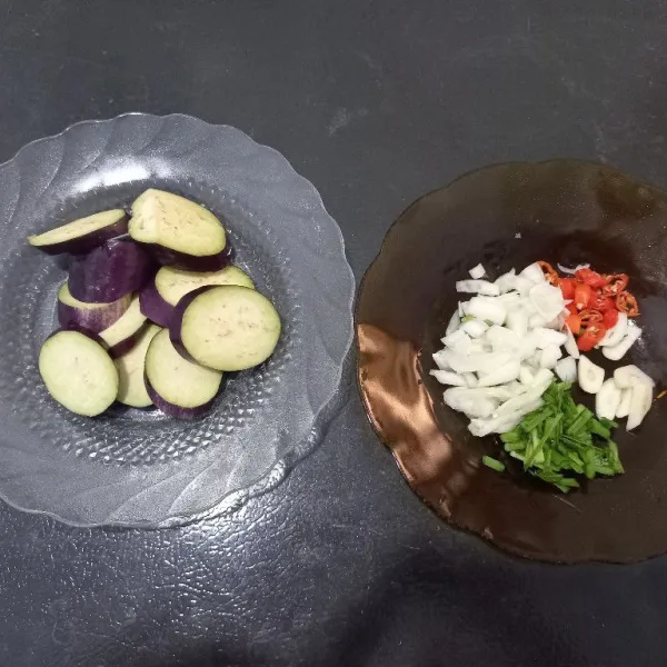 Pertama-tama siapkan terong ungu, bawang putih, bawang bombai, cabai rawit, dan kucai.