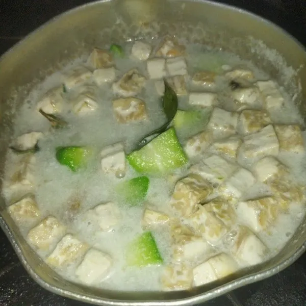 Masukkan tempe dan labu siam, aduk rata. Masak hingga labunya matang. Beri garam dan gula pasir, aduk rata.