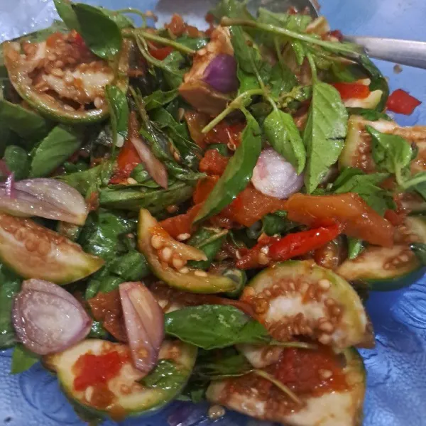 Campurkan irisan terong dan irisan bawang merah dengan bahan sambal, aduk rata.