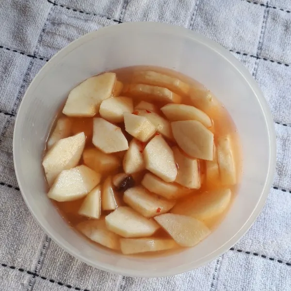 Letakkan pir dalam wadah kedap udara, siram dengan kuah asinan, aduk rata. Tutup dan simpan dalam kulkas semalaman. Sajikan.
