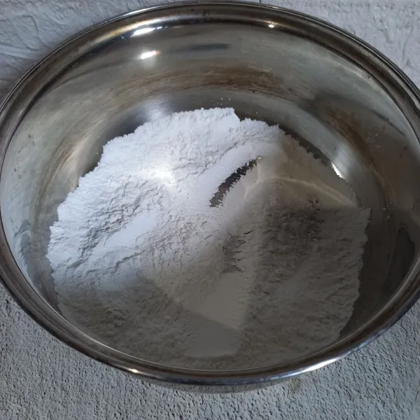 Masukkan tepung beras dan garam ke dalam panci. Kemudian aduk-aduk.