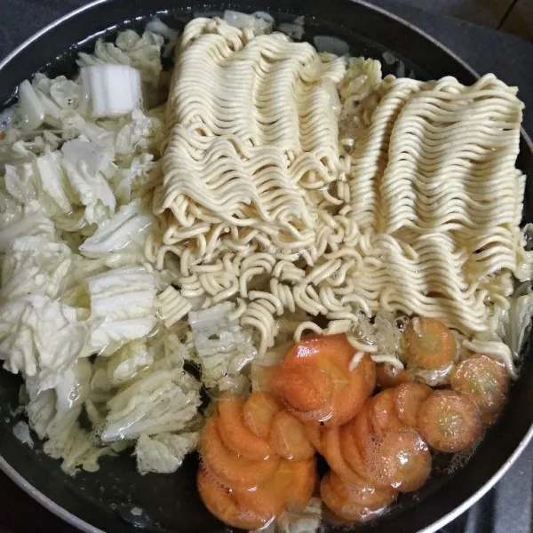 Masukkan sayuran dan mie. Tunggu sampai setengah matang.