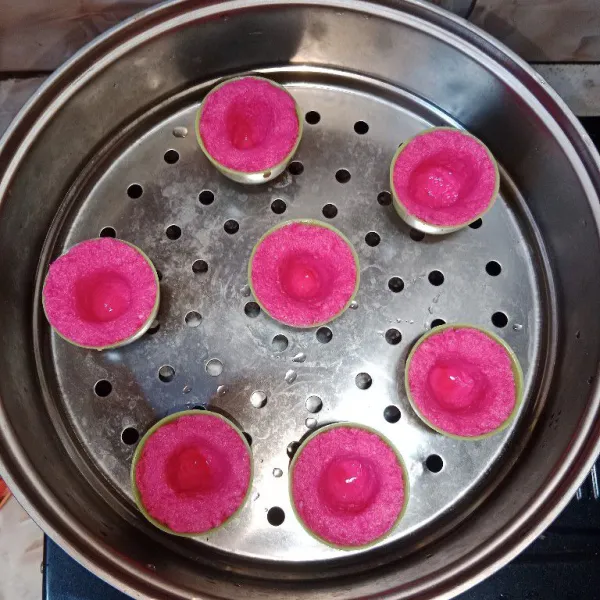 Ambil adonan merah, masukkan ke dalam cetakan yang sudah dioles minyak lalu buat lubang di tengah lalu kukus selama 5 menit.