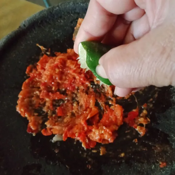 Ulek bahan sambal, garam, gula pasir, kaldu bubuk, ulek sedikit kasar dan beri perasaan jeruk nipis, aduk rata, koreksi rasa.