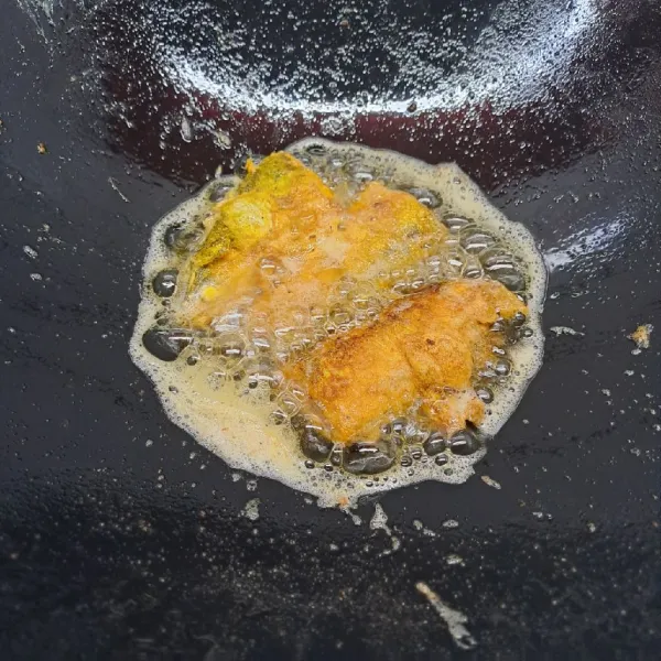 Kocok telur, masukkan ikan bandeng. Kemudian goreng ikan sampai kecoklatan di kedua sisi. Angkat dan taruh di piring saji.