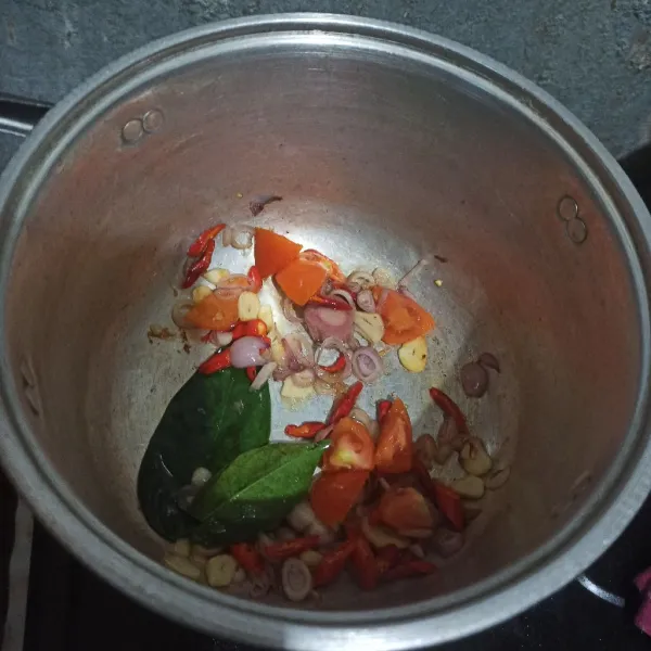 Tumis bumbu iris bersama daun salam, dan laos hingga harum.