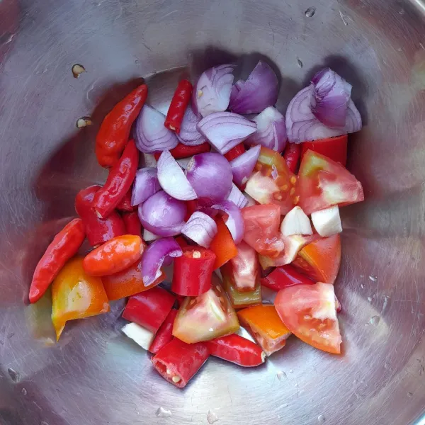 Cuci bersih cabai merah keriting, cabai merah besar, cabai rawit merah, tomat merah, bawang merah dan bawang putih. Tiriskan kemudian potong-potong.