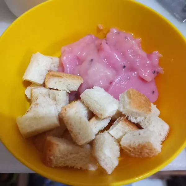 Ambil bubur sumsum di mangkok. Beri pinggiran roti tawar, potong kecil.