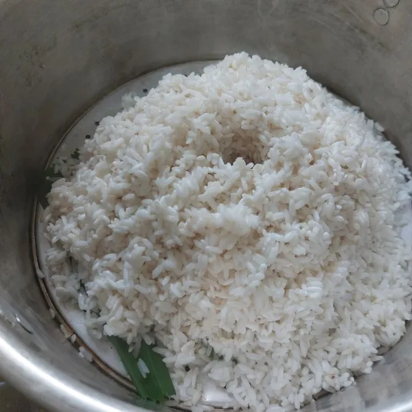 Kukus beras ketan hingga matang dengan selembar daun pandan