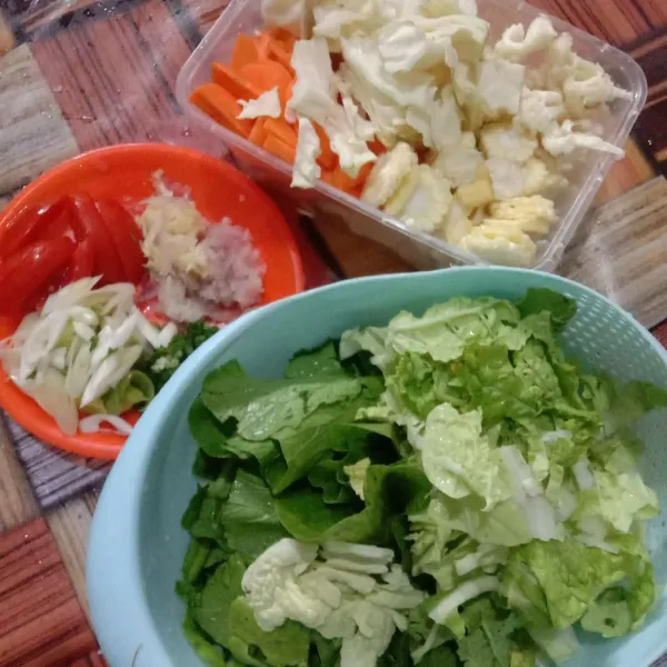 Potong-potong sayuran dan haluskan bawang merah, bawang putih dan tomat merah.
