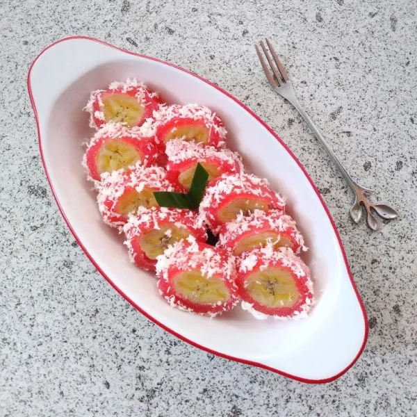 Potong-potong kue kemudian balur dengan kelapa parut. Sajikan.