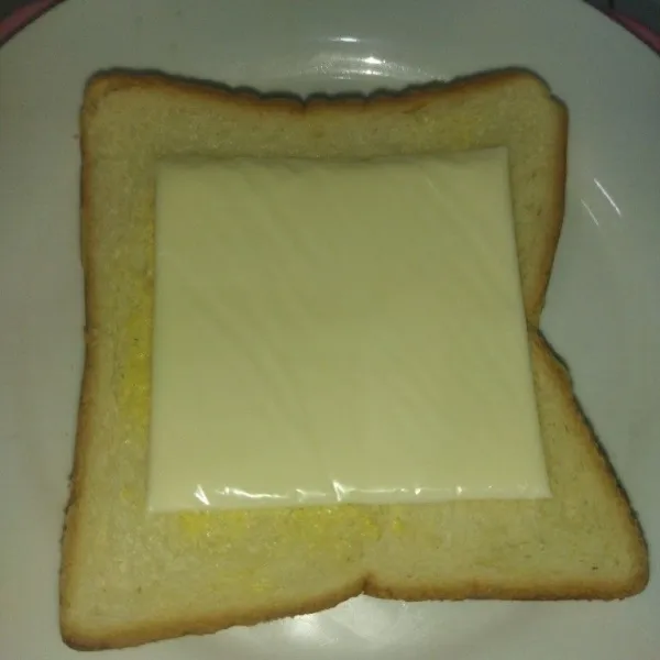 Ambil 1 lembar roti tawar, lalu oles dengan margarin secukupnya, lalu tata 1 lembar keju tutup dengan 1 lembar roti.
