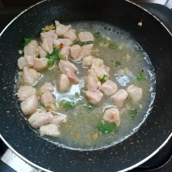 Masukkan ayam, tumis sampai ayam berubah warna. Kemudian tuang air, biarkan mendidih.