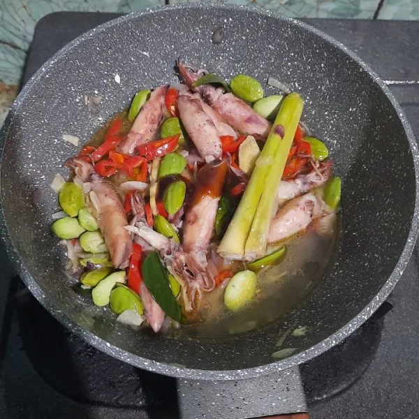 Masukkan air matang, kecap manis, gula, dan kaldu jamur. Aduk rata lalu tes rasa. Masak sampai cumi matang.