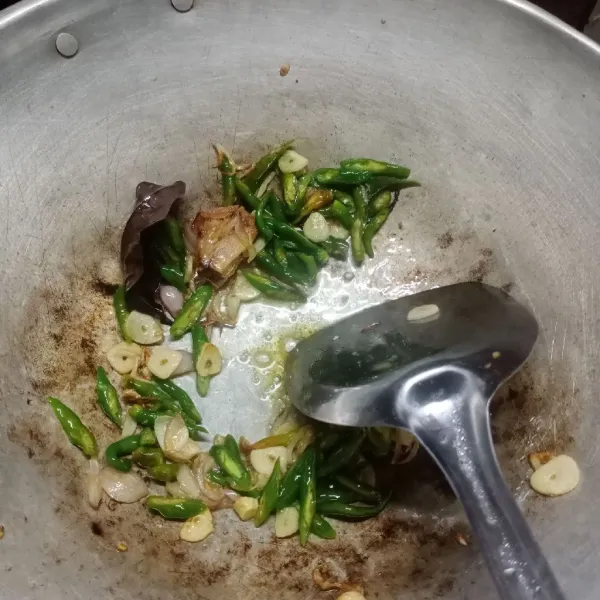 Tumis bawang merah, bawang putih, cabe hijau keriting, daun salam dan lengkuas sampai harum.