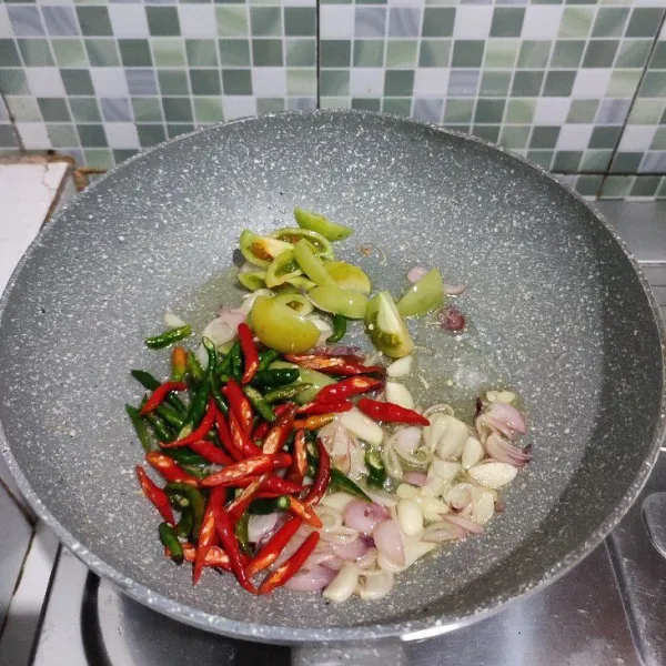 Masukkan tomat hijau, cabe hijau, dan cabe merah. Aduk rata.