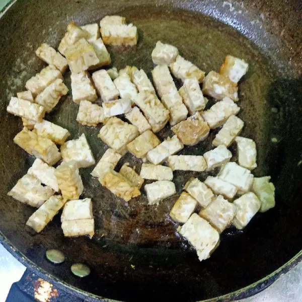 Siapkan wajan lalu beri minyak sedikit, lalu masukkan potongan tempe. Oseng tempe sampai matang semuanya.
