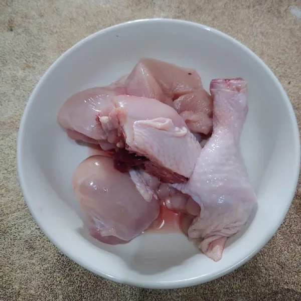 Cuci hingga bersih daging ayam dan potong beberapa bagian.