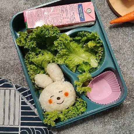 Siapkan nasi putih di dalam bento box. Bentuk seperti kelinci atau karakter lain sesuai selera.