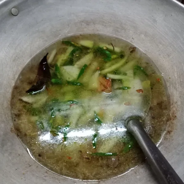 Masukkan labu siam, aduk rata. Tuang air, biarkan mendidih. Masak sampai labu siam setengah matang.
