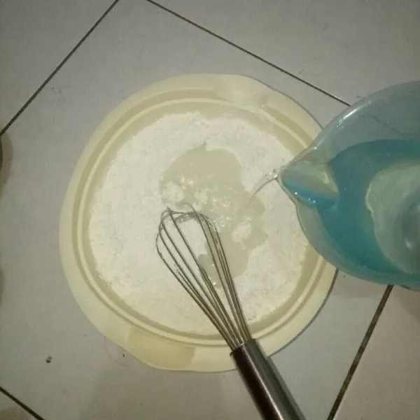 Siapkan wadah, masukkan tepung terigu, gula pasir, baking powder dan soda kue. Aduk rata sambik di tuangi air secara perlahan, aduk rata.