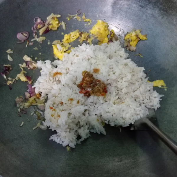 Masukkan nasi, sambal bawang, garam dan penyedap rasa. Aduk-aduk hingga keluar aroma harum.