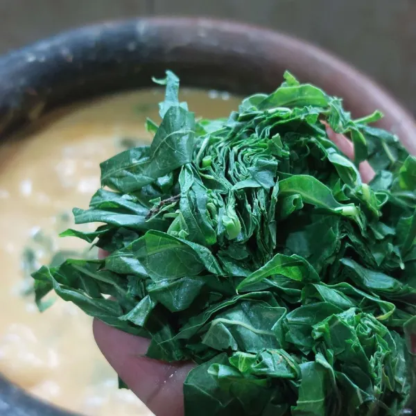 Tambahkan daun singkong, kecilkan api.