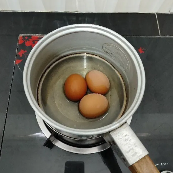 Rebus telur hingga matang, lalu kupas dan sisihkan.
