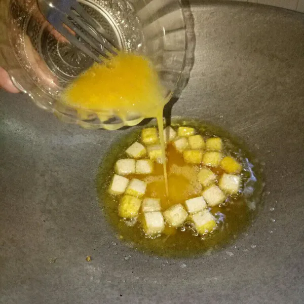 Kocok lepas telur, bumbui garam secukupnya. Siapkan pan dan panaskan minyak, potong dadu tahu lalu goreng sampai setengah matang lalu masukkan telur kocok ke pan. Goreng sampai tahu dan telur matang, angkat. Setelah dingin iris dadu.