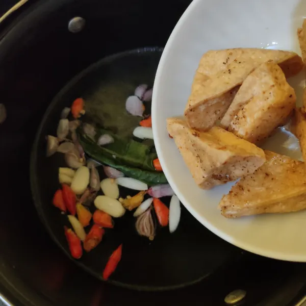 Masukkan tahu, kaldu bubuk dan gula pasir. Masak hingga mendidih, tes rasa.